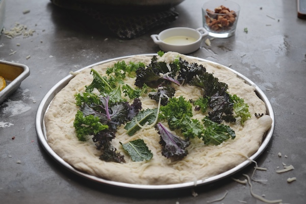 Roasted Delicata Squash Kale Pizza with sausage, caramelized onions and candied walnuts! Recipe on shutterbean.com