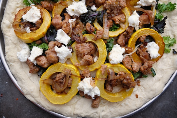 Roasted Delicata Squash Kale Pizza with sausage, caramelized onions and candied walnuts! Recipe on shutterbean.com