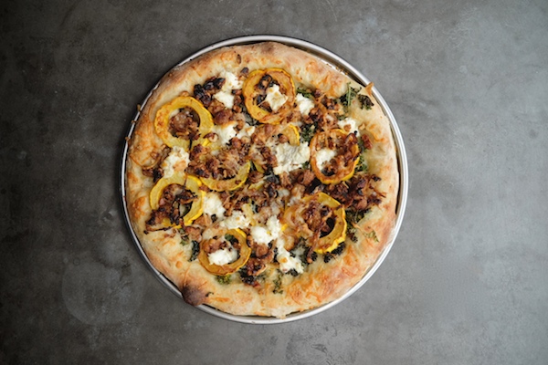 Roasted Delicata Squash Kale Pizza with sausage, caramelized onions and candied walnuts! Recipe on shutterbean.com