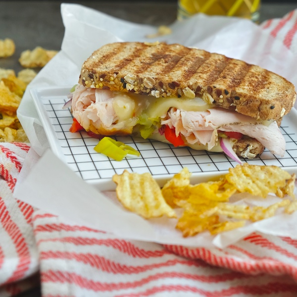 Grilled Turkey Pepper Jack Sandwich made with Dave's Killer Bread. There's roasted peppers & pepperoncini nestled in there! Find the recipe on Shutterbean.com!