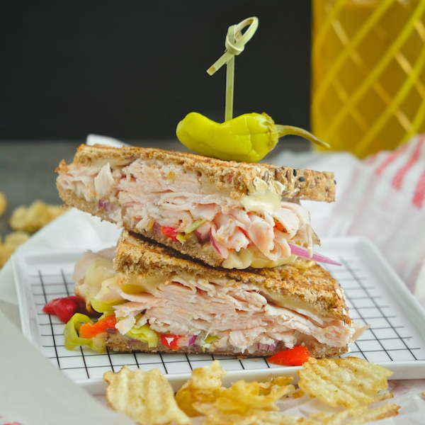 Grilled Turkey Pepper Jack Sandwich made with Dave's Killer Bread. There's roasted peppers & pepperoncini nestled in there! Find the recipe on Shutterbean.com!