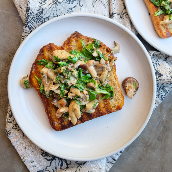 Creamy Mushroom Arugula Toast with Poached Eggs. Find the recipe on Shutterbean.com