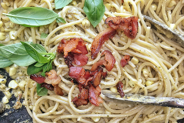 Creamy Corn Basil Pasta studded with crispy bacon. Find the recipe on Shutterbean.com