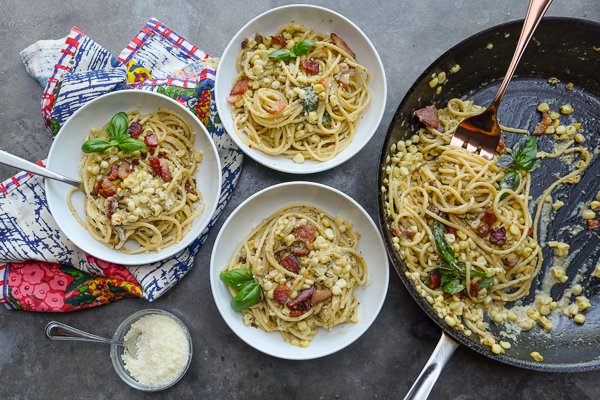 Creamy Corn Basil Pasta studded with crispy bacon. Find the recipe on Shutterbean.com