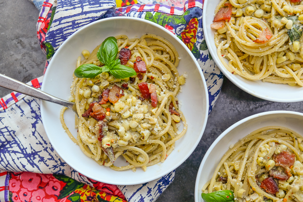 Creamy Corn Basil Pasta studded with crispy bacon. Find the recipe on Shutterbean.com