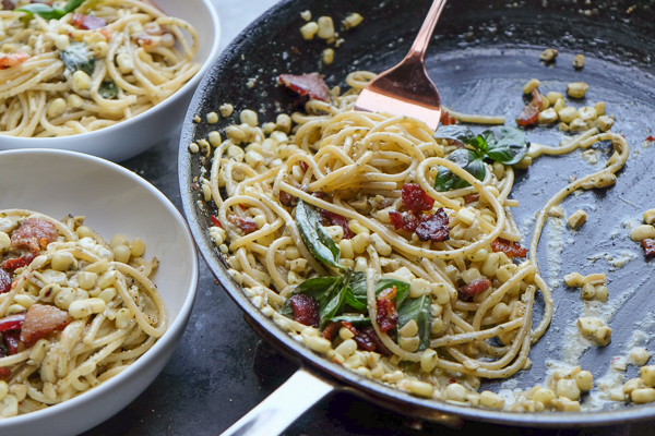 Creamy Corn Basil Pasta studded with crispy bacon. Find the recipe on Shutterbean.com