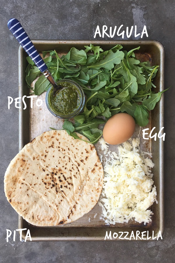 Try this Egg-In-A-Hole Pesto Pizza made with pita bread for a healthy breakfast. Recipe on Shutterbean.com!