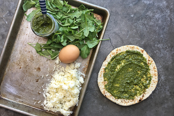 Try this Egg-In-A-Hole Pesto Pizza made with pita bread for a healthy breakfast. Recipe on Shutterbean.com!