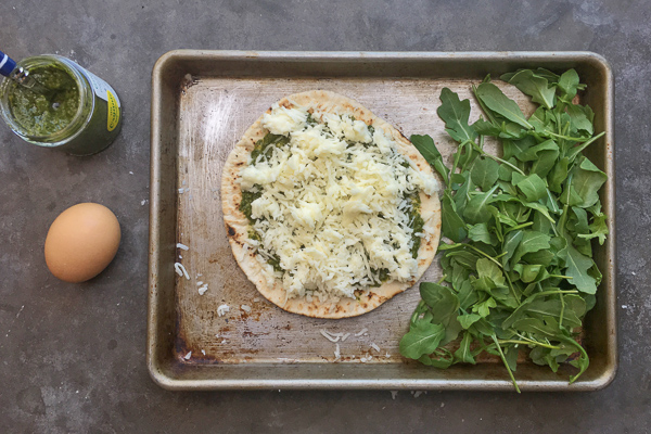 Try this Egg-In-A-Hole Pesto Pizza made with pita bread for a healthy breakfast. Recipe on Shutterbean.com!