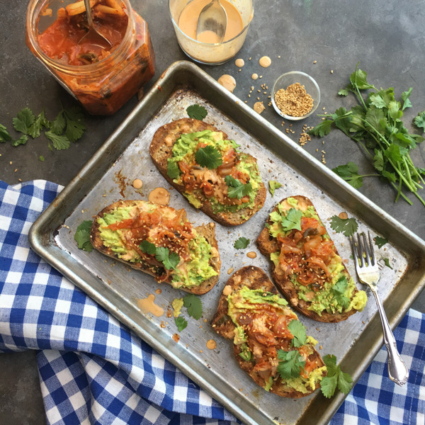 This isn't ordinary avocado toast. It's Avocado Kimchi Toast with a spicy tahini drizzle. Find recipe at Shutterbean.com