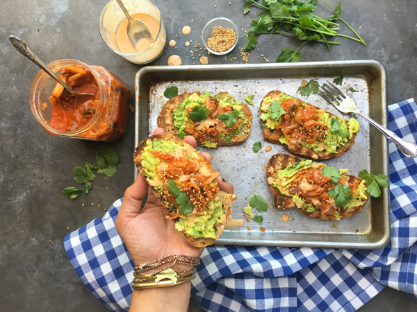 This isn't ordinary avocado toast. It's Avocado Kimchi Toast with a spicy tahini drizzle. Find recipe at Shutterbean.com