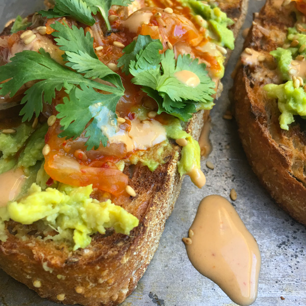 This isn't ordinary avocado toast. It's Avocado Kimchi Toast with a spicy tahini drizzle. Find recipe at Shutterbean.com