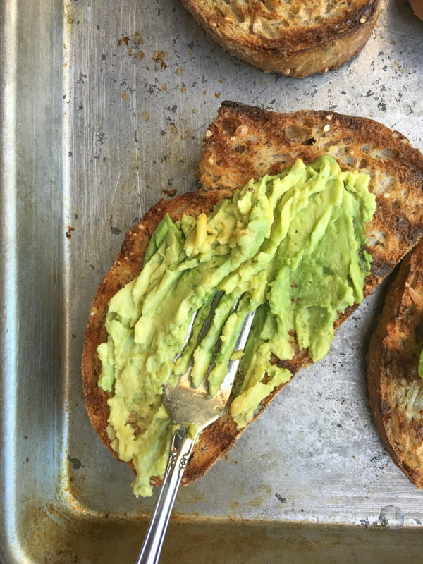 This isn't ordinary avocado toast. It's Avocado Kimchi Toast with a spicy tahini drizzle. Find recipe at Shutterbean.com