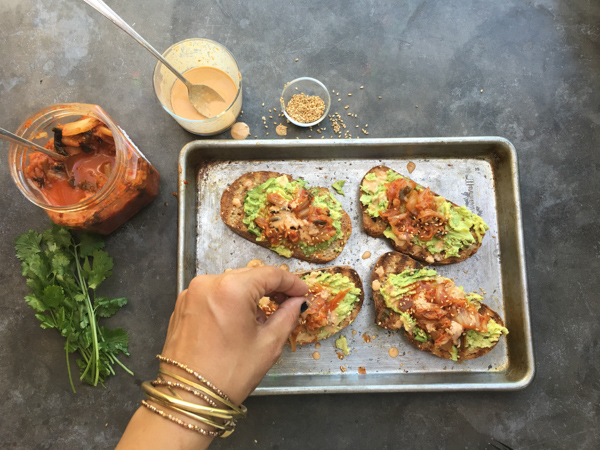 This isn't ordinary avocado toast. It's Avocado Kimchi Toast with a spicy tahini drizzle. Find recipe at Shutterbean.com