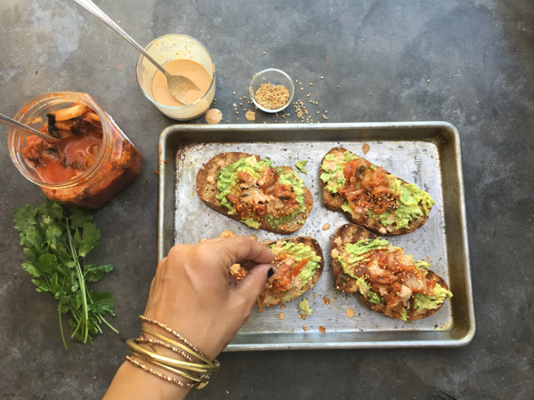 This isn't ordinary avocado toast. It's Avocado Kimchi Toast with a spicy tahini drizzle. Find recipe at Shutterbean.com