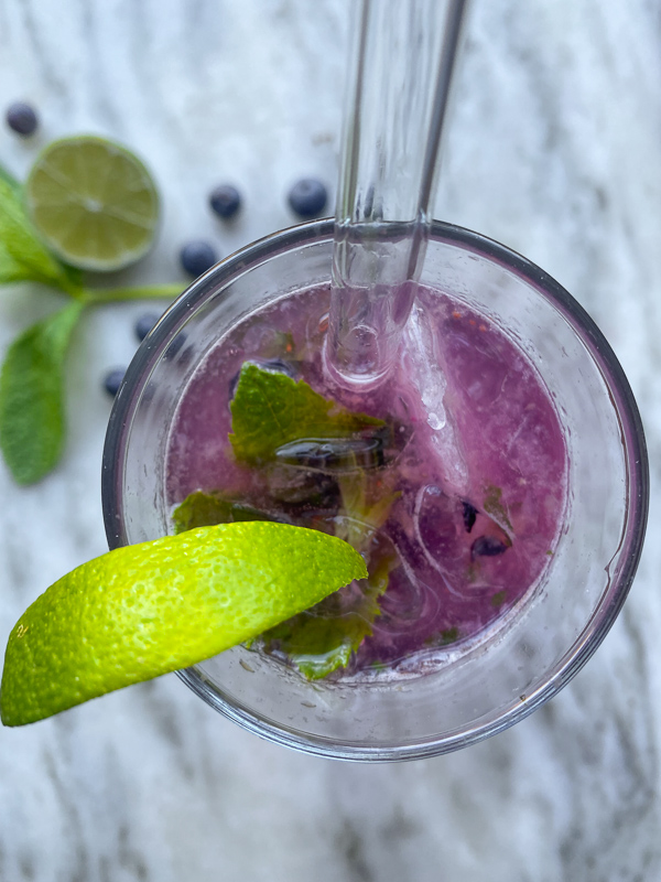 Blueberry Mojito is a refreshing cocktail! Muddled mint and blueberries add color to your life! Find the recipe on Shutterbean.com