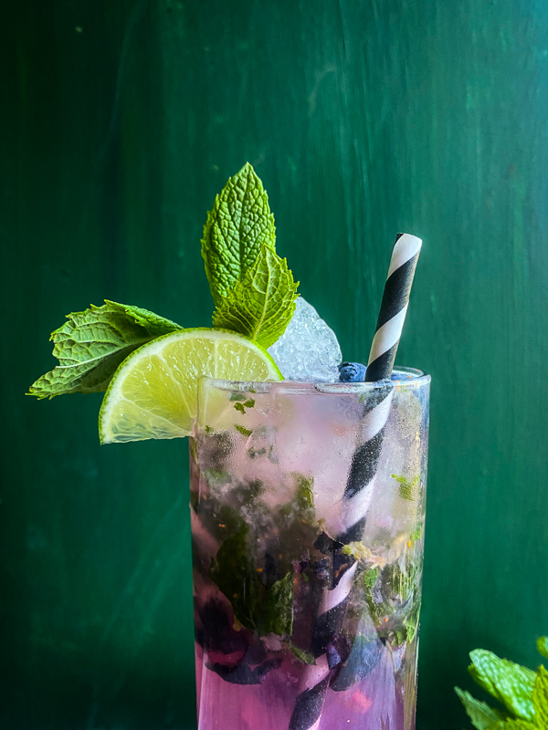 Blueberry Mojito is a refreshing cocktail! Muddled mint and blueberries add color to your life! Find the recipe on Shutterbean.com