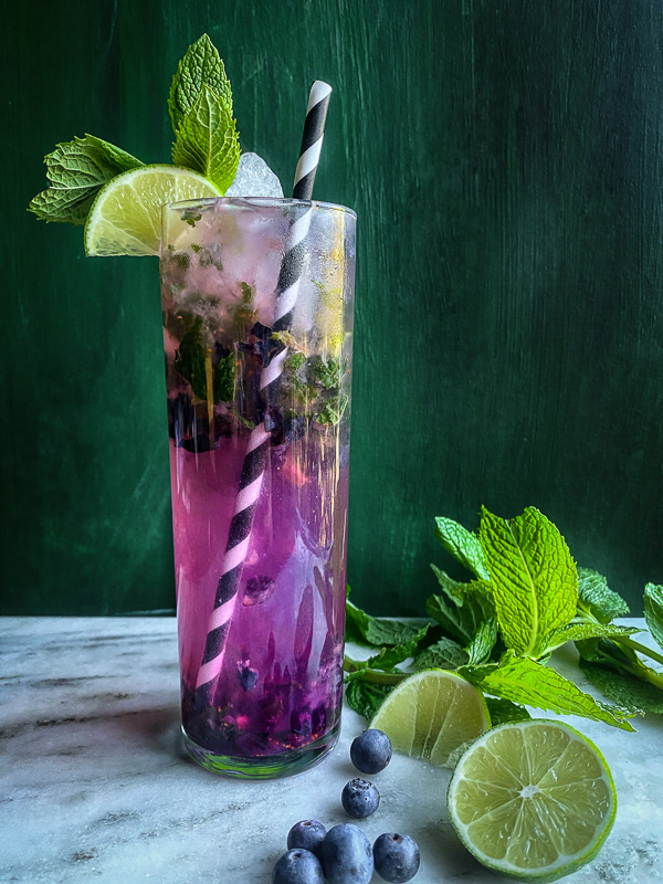 Blueberry Mojito is a refreshing cocktail! Muddled mint and blueberries add color to your life! Find the recipe on Shutterbean.com