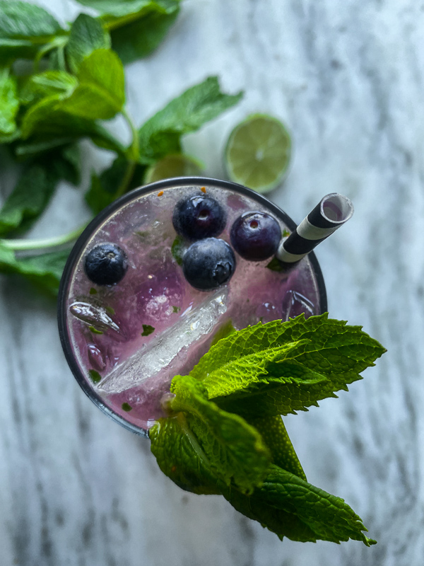 Blueberry Mojito is a refreshing cocktail! Muddled mint and blueberries add color to your life! Find the recipe on Shutterbean.com