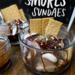 S'mores Sundaes are a combination of chocolate ice cream, marshmallow fluff and hot fudge! Don't forget the graham crackers. Find the recipe on Shutterbean!
