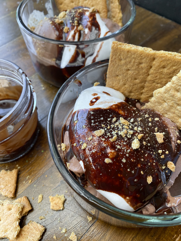 S'mores Sundaes are a combination of chocolate ice cream, marshmallow fluff and hot fudge! Don't forget the graham crackers. Find the recipe on Shutterbean!