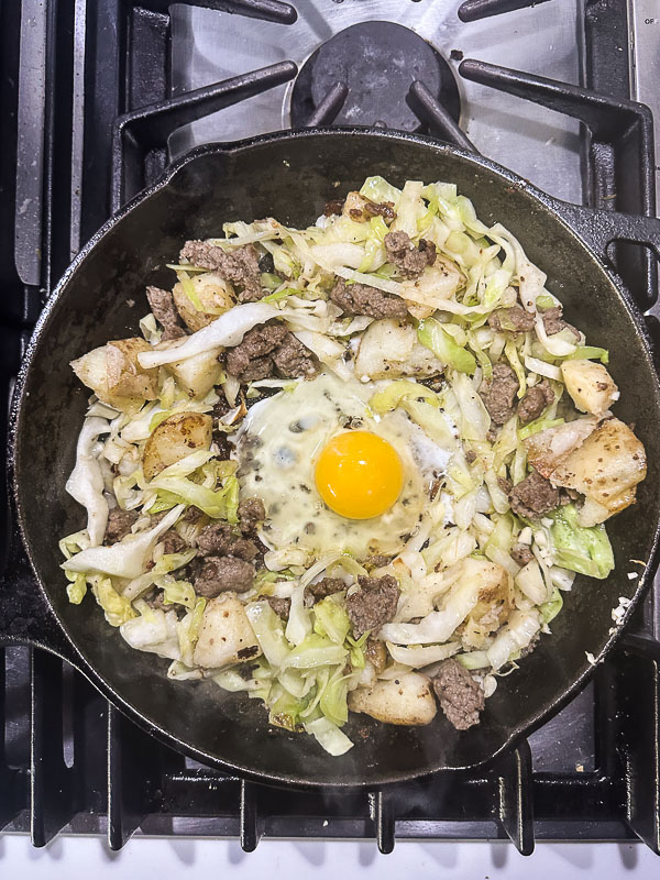 Cabbage Sausage Hash with potatoes, Parmesan topped with a fried egg! Recipe on Shutterbean.com