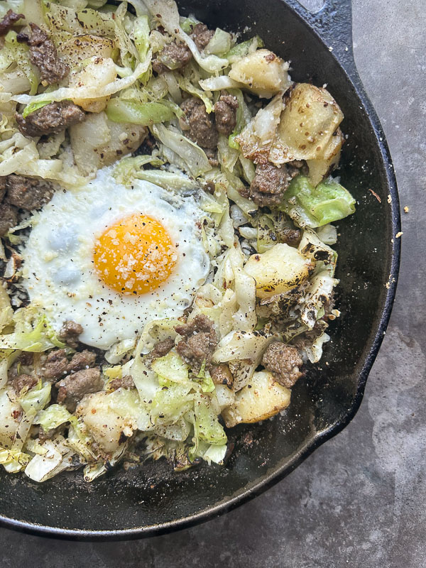 Cabbage Sausage Hash with potatoes, Parmesan topped with a fried egg! Recipe on Shutterbean.com