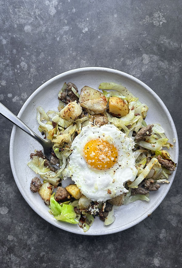 Cabbage Sausage Hash with potatoes, Parmesan topped with a fried egg! Recipe on Shutterbean.com