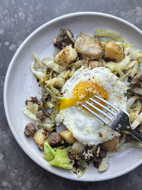 Cabbage Sausage Hash with potatoes, Parmesan topped with a fried egg! Recipe on Shutterbean.com