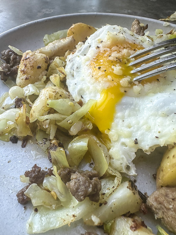 Cabbage Sausage Hash with potatoes, Parmesan topped with a fried egg! Recipe on Shutterbean.com